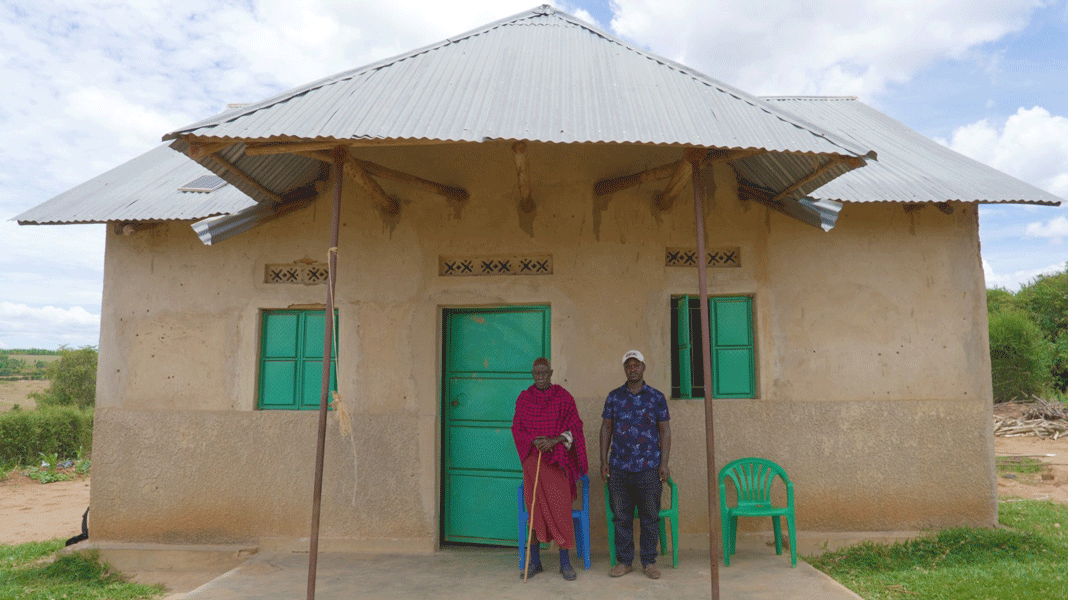 two men outside house in Uganda village